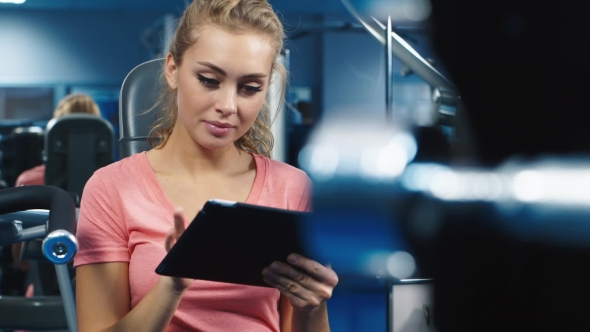 Attractive Woman Using a Tablet in the Gym alt