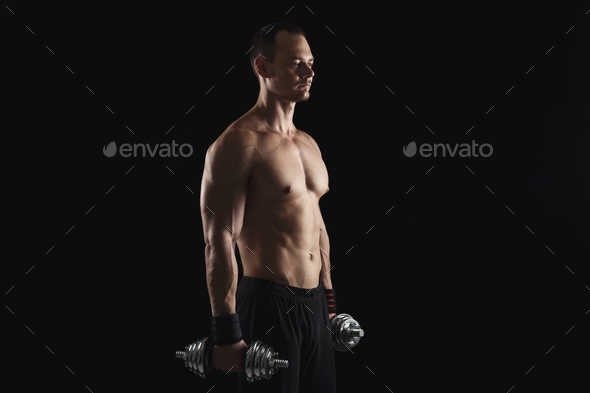 Strong athletic man with dumbbell showes naked muscular body - Stock Photo - Images