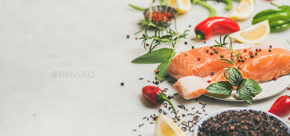 Raw uncooked salmon steaks with vegetables, greens and rice - Stock Photo - Images