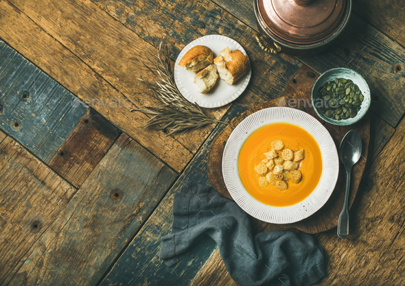Warming pumpkin cream soup with croutons and seeds, copy space - Stock Photo - Images