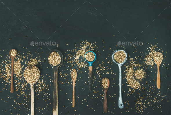 Various kitchen spoons full of green buckwheat grains, copy space - Stock Photo - Images