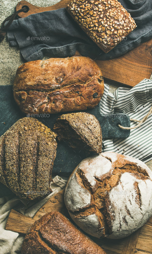 Flat-lay of various bread loaves on grey background, top view - Stock Photo - Images