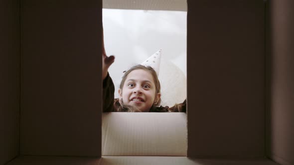 Cute Female Child with Surprised Emotions Upacking Gift alt