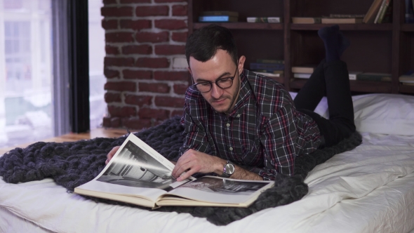 Young Bearded Man with Glasses Reading the Book