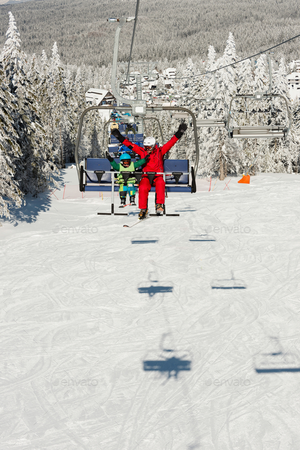 Little boy with ski instructor enjoying on ski lift Stock Photo by microgen