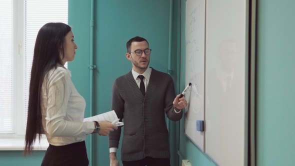 Business Man and Woman Discussing Something Near Whiteboard