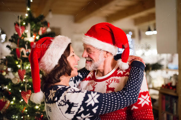 Senior couple with Santa hats at Christmas time. - Stock Photo - Images
