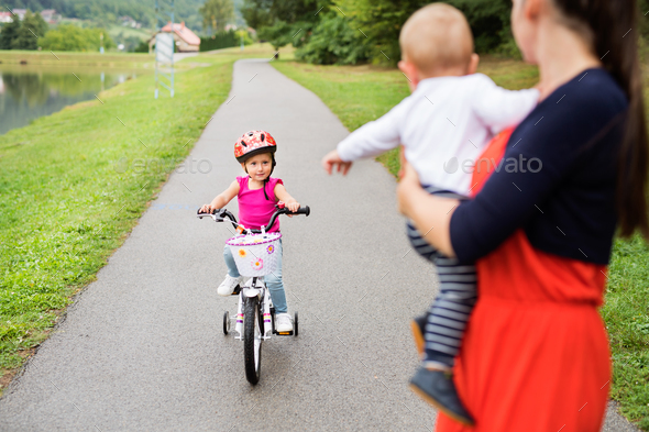 Little girl with her mother and brother in the nature. - Stock Photo - Images