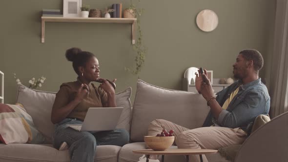 Black Man Taking Picture of His Girlfriend with Pet Snake at Home alt