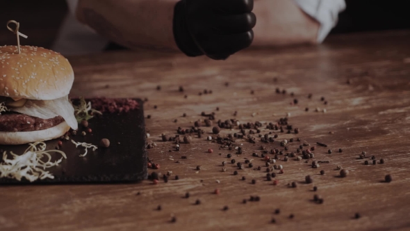 Burger , Salades, Fresh Vegetables, Tomato Sauce on Serving Dark Wooden Board and Man's Fingers