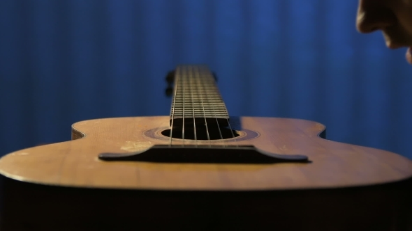 Man Blows Dust Off Old Acoustic Guitar