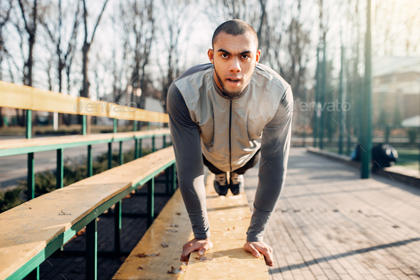 Male athlete warming up before run in autumn park - Stock Photo - Images