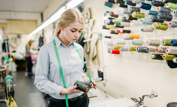 Clothes designer with color threads in hands - Stock Photo - Images