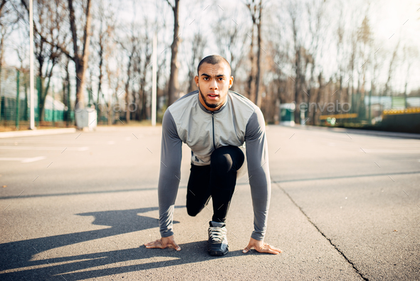 Male athlete prepares to run in autumn park - Stock Photo - Images