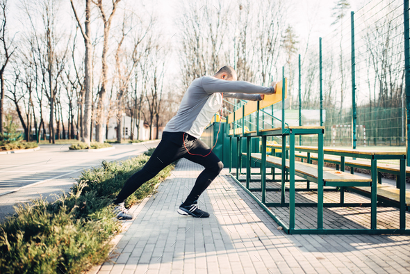 Runner doing stretching exercise before training - Stock Photo - Images