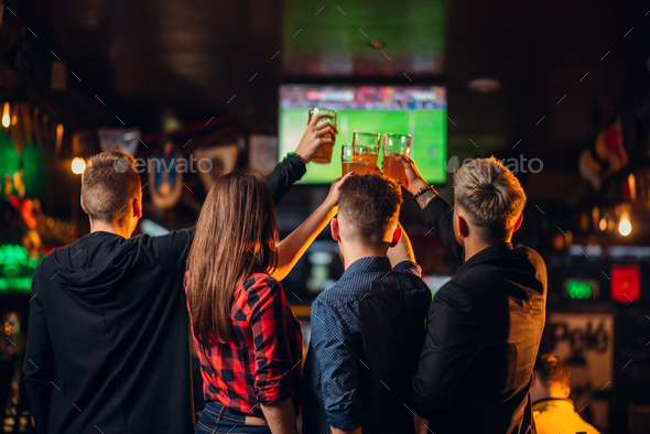 Friends watches football on TV in a sport bar - Stock Photo - Images