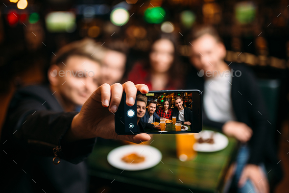 Fun friends makes selfie on phone in a sport bar - Stock Photo - Images