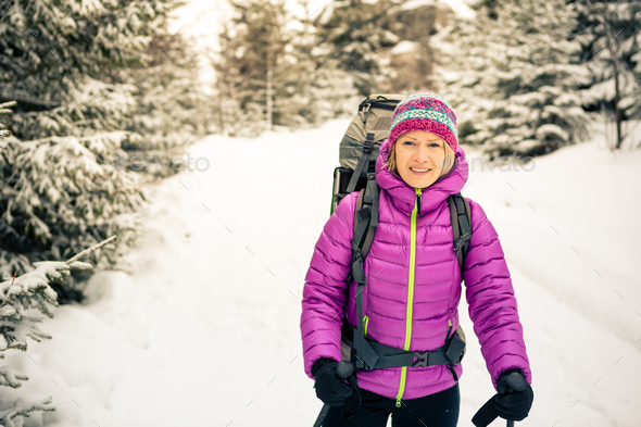 Happy woman walking in winter forest with backpack - Stock Photo - Images