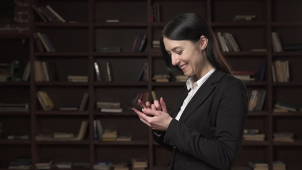 Successful Business Woman Using Smartphone in the Library