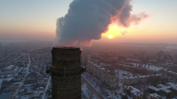 Aerial  Shot of a Big Industrial Tower with White Smoke at Sunset in Winter