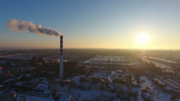 Aerial Shot of an Elevated Hot Gas Chimney with Dark Smoke at Sunset in Winter