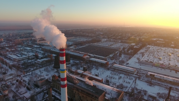Aerial Shot of a High White and Red Tower with White Smoke at Sunset in Winter