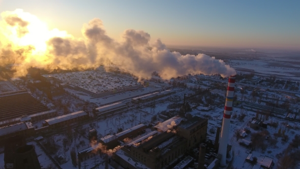 Aerial Shot of a Sky-high Hot Gas Tower with White Smoke at Sunset in Winter