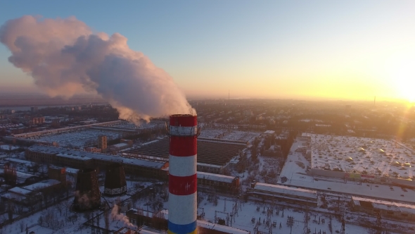 Aerial  of a Gigantic Cooling Tower with White Smoke at Sunset in Winter