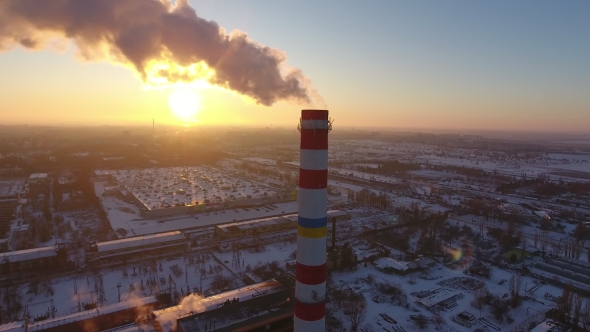 Aerial Shot of a Sky-high Boiler Tower with White Smoke at Sunset in Winter