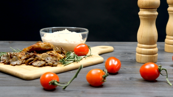 Pork Chops with Grilled Mushrooms, Bean Pasta and Cherry Tomatoes on a Table alt