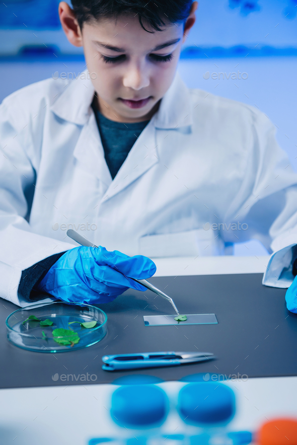 Schoolboy using lab equipment, laboratory education concept Stock Photo by microgen