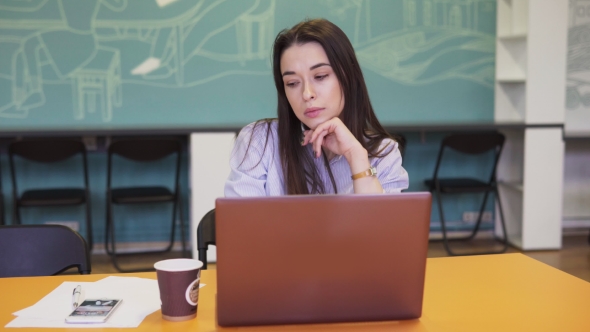 Serious Woman Working on Laptop in Office