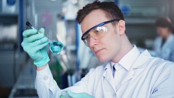 Young Scientist Checking Test Tubes in the Lab. Man Wears Protective ...