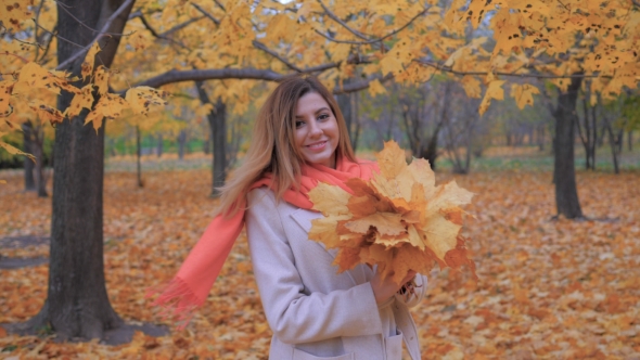 Lady In A Beige Coat Standing Back And Turns Around, Holding Bouquet Leaves alt