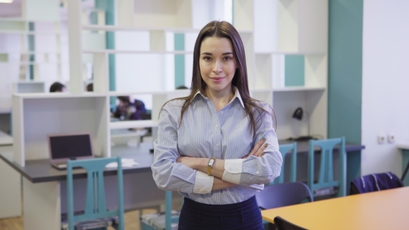 Confident Business Woman Standing with Arms Crossed in Office