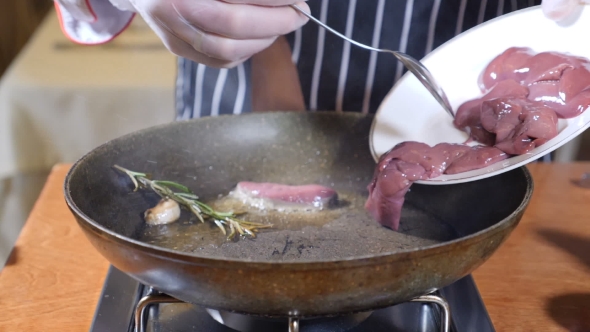 Chef Cooking Flambe Style Dish with Slices of Liver on a Hot Frying Pan in Restaurant alt