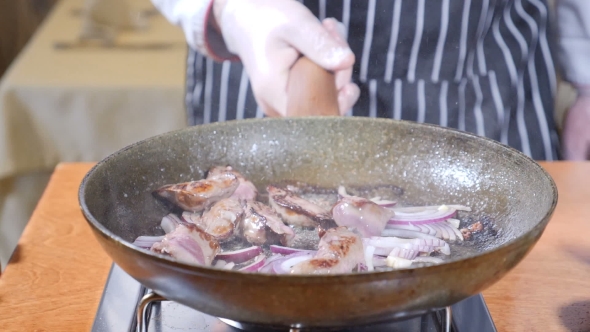 of Chef Cooking Flambe Style Dish with Slices of Liver on a Hot Frying Pan in Restaurant Stirring alt