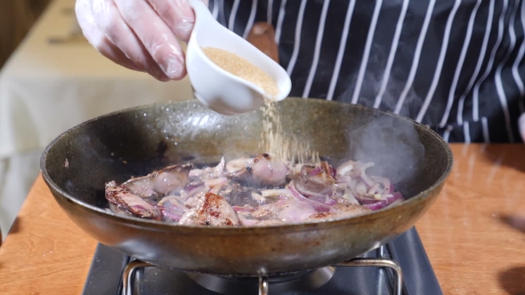 Chef Cooking Flambe Style Dish with Slices of Liver on a Hot Frying Pan in Restaurant alt