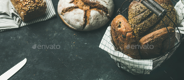 Various bread loaves on grey concrete background, copy space - Stock Photo - Images