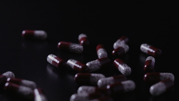 Medical Pills Scattered on the Black Table alt