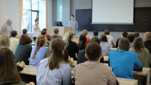 Group of University Students Sitting at Their Desks in Auditorium and Listening
