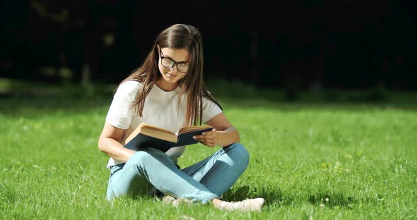 Woman Reading Book in Park