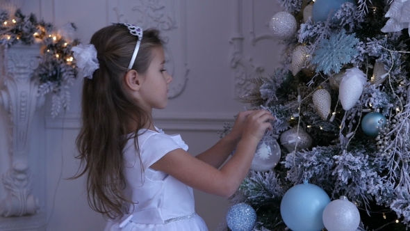 Child Decorating the Christmas Tree, Little Girl Decorating the Christmas Tree