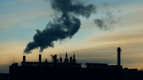 Smoke Slowly Comes Out of Several Pipes in the Factory Against the Sky at Sunset