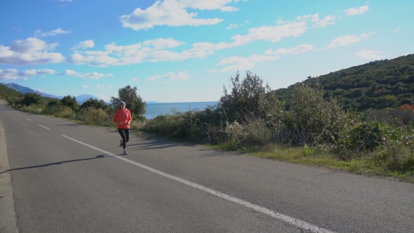 Outdoor Shot of Fitness Woman Running on Open Country Road