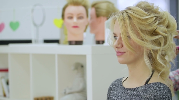 Cute Blonde Girl Looks in the Mirror at the Beauty Salon alt