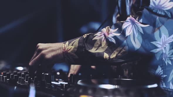 Professional disc jockey mixing music on stage in night club alt