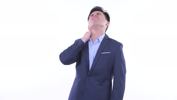 Stressed Young Asian Businessman Having Neck Pain alt