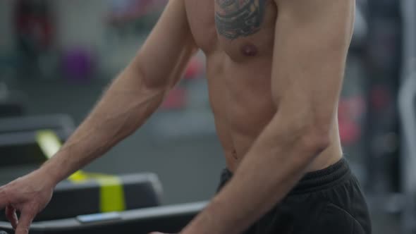 Live Camera Goes Up As Confident Fit Sportsman Running on Treadmill in Gym alt