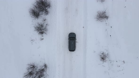 Aerial Top View Car Driving on Road Covered With Snow